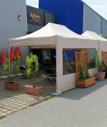 2 folding gazebo measuring 4.5x3 m stand in front of the Käser bakery in Vilshofen. They serve as canopies for the guests.